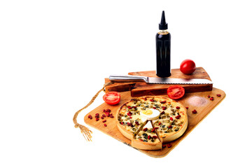 Pizza on a cutting board with a bread knife. Tomatoes, sauce , egg.