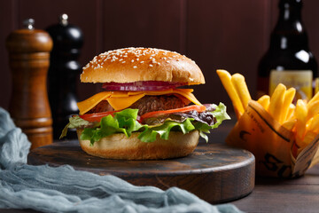 Burger classique fait maison sur une planche rustique avec des frites