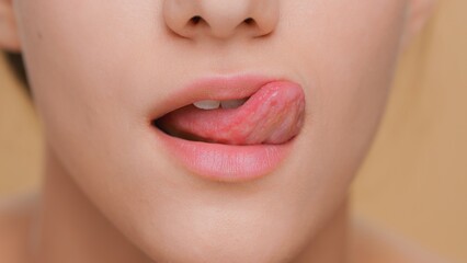 Detail shot of young woman licking her lips