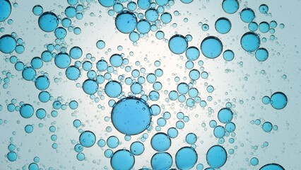 Macro shot of blue oil drops and bubbles floating in clear liquid against pale blue background | Abstract skin care ingredients 