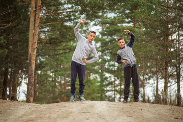 Fototapeta premium boys exercises outside, stretching his shoulder and back muscles