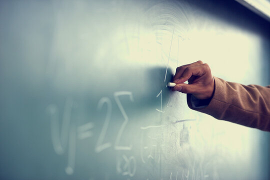 Its all greek to me. Cropped image of a teacher writing a formula on a blackboard.