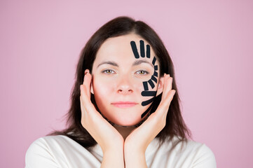 Kinesiotaping concept. Portrait of woman with tape on her face. Physiotherapy and cosmetology...