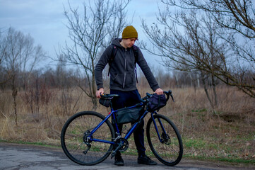 Middle-aged guy cyclist in the forest in spring in cloudy weather. Road bike. gravel bike. bike rides. travel light. healthy lifestyle