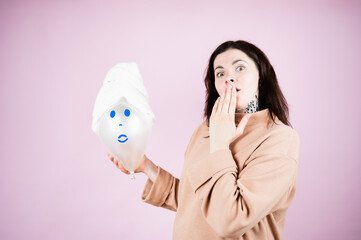 Spa girl. Emotional woman covers her mouth in surprise on pink background. Gift Certificate concept