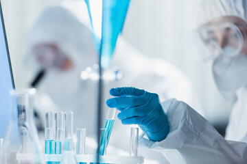 blurred bioengineer in latex glove working with test tubes in laboratory.