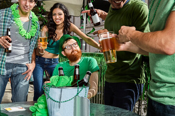 Man sitting down while all his friends party and have fun around him during St Patrick's Day