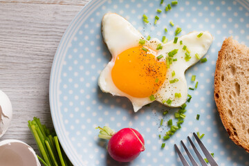 Fried egg with chives and radish, healthy spring breakfast concept  - obrazy, fototapety, plakaty
