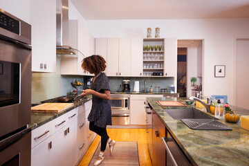 Female ballet dancer cooking in a residential kitchen