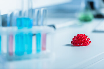 selective focus of red coronavirus bacteria on blurred foreground in chemical lab.