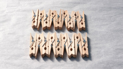 Montón de pinzas de madera para colgar la ropa ordenadas en fila sobre papel blanco