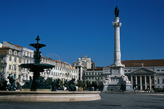 Low angle view of a fountain in front of buildings, Rossio Square, Lisbon, Portugal