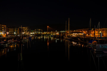 Night view of sailboats moored on the Nidelva river in Trondheim, Norway