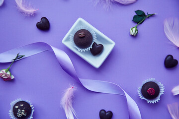 Chocolate sweets and hearts. Trendy pink feathers. Delicate purple very peri color pattern. Birthday, invitation, greetings and wishing concept