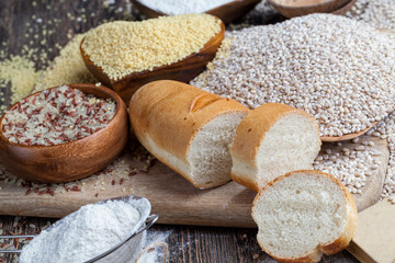 wheat baguette on the table with flour and various plant grains