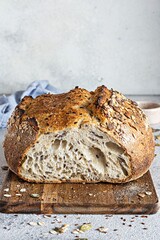 Fresh homemade bread (slice) from whole grain sourdough flour with the addition of bran, seeds (sunflower, pumpkin, flax, sesame) and oatmeal flakes. Healthy food. High quality photo.