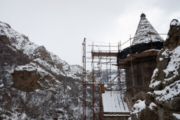 restoration of the tower of an ancient temple among the mountain peaks