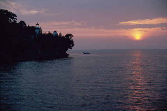 Silhouette of a boat in the sea during sunset