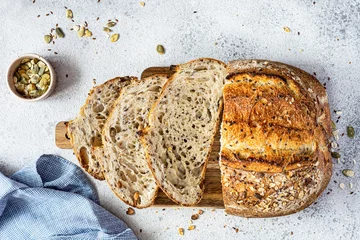 Gordijnen Fresh homemade bread (slice) from whole grain sourdough flour with the addition of bran, seeds (sunflower, pumpkin, flax, sesame) and oatmeal flakes. Healthy food. High quality photo. © VIKTORIIA DROBOT