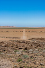 Namibia, panorama of the Namib desert, wild landscape with a dirt road in background
