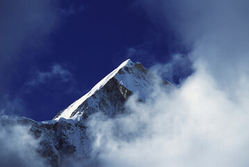 Low angle view of a mountain peak surrounded by clouds, Mount Lingtren, Nepal