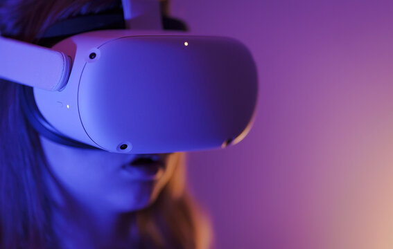Amazed little girl using VR headset close-up