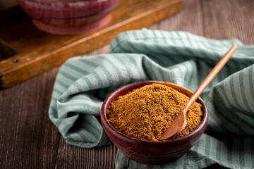 Brown sugar in wooden bowl on the table.