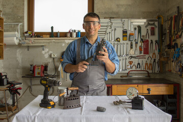 Smiling man in his workshop while restoring antiques.