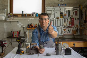 Smiling handyman man with thumbs up after restoring antiques.