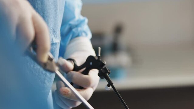 The surgeon's holing the instrument in abdomen of patient. The surgeon's doing laparoscopic surgery in the operating room. Minimally invasive surgery. Operation using laparoscopic equipment.