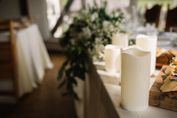 Boho wedding and decorations for stylish modern outdoor ceremony in summer from event agency. Candles, dry lowers, accessories, glasses and plate on table for guest on green lawn, flat lay, free space