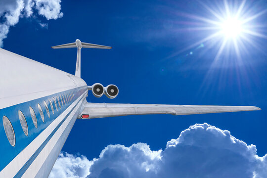 Airplane in blue cloudy sky. White passenger jet fly among clouds. Travel by air transport
