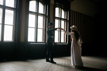 Happy young couple. Brides in hats. Young girl in a white wedding dress and hat with a bouquet of flowers. Brides in the castle. Bride and groom.