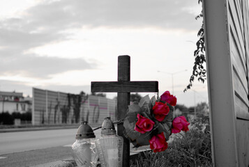 View of roadside memorial with cross, candles and flowers. All Souls' Day