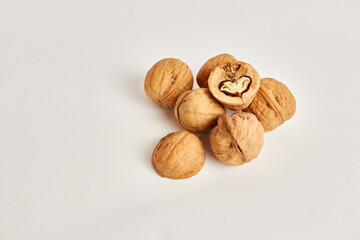 Whole and split walnuts on a white background.