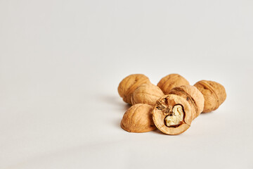 Whole and split walnuts on a white background.