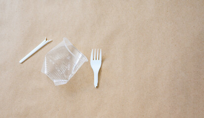Plastic trash on a paper background. Flat lay, copy space.