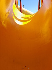 Tobogàn de cilindro de plàstico amarillo para juegos de niños en el parque infantil, con la...