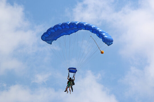 Tandem Skydiver flying wing in a blue sky	