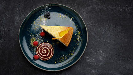 Cheesecake with orange chips and raspberries, on a plate