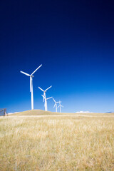 Beautiful windmills with the blades in motion. Deep azure sky with bright white. Polarized photo...