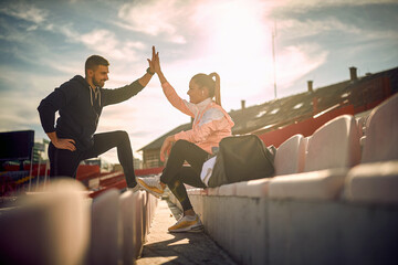 satisfied beardy guy and beautiful female giving high-five to each other after successful training