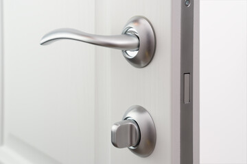 Modern door handle with lock and magnetic pawl. White wooden Interior door, close up.
