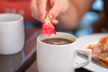 white cup with hot coffee drink with powder ingredient sachet