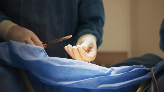 Close-up on Professional Surgeon Suture Wound after Successful Surgery. In the Background Modern Hospital Operation Room. Shot on RED EPIC.