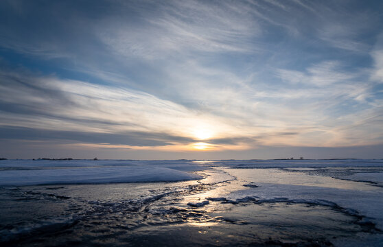 Ice reflection on a frozen lake at sunset in Newell County Alberta Canada.