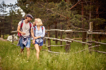 A young couple in love is in a good mood while hiking in the nature. Hiking, relationship, nature, activity