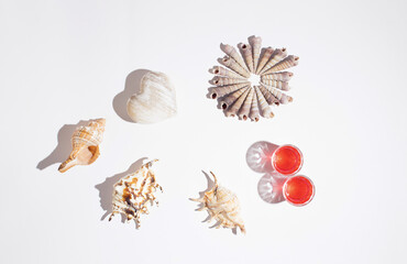 Fresh red cocktail with drink straw and seashells. Tropical beach, summer, sea, vacation and travel concept with copy space.