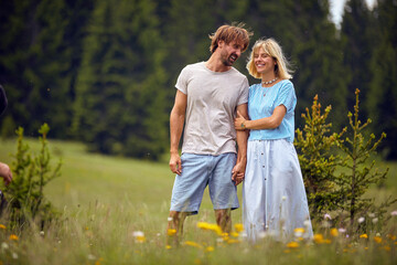 Fototapeta premium A young couple in love enjoys a walk the nature. Relationship, love, nature, activity