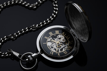 Pocket round watch with cap and chain on dark gradient background